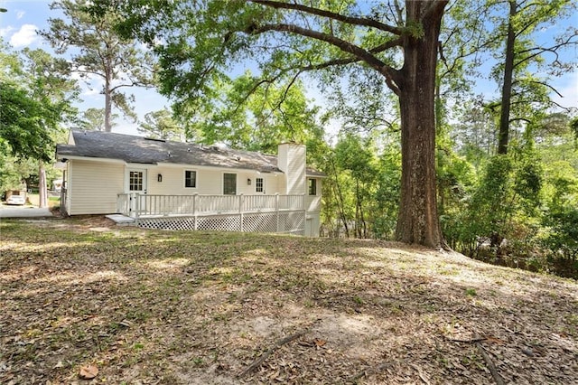 back of property featuring a deck and a chimney
