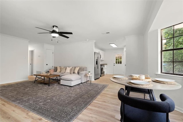 living room with ceiling fan, baseboards, visible vents, and light wood-style floors