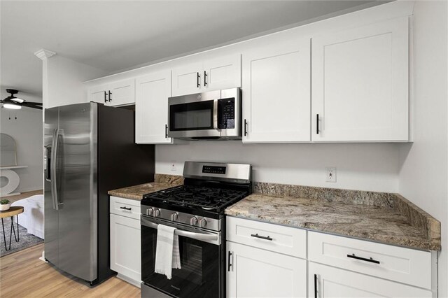 kitchen featuring white cabinets, ceiling fan, appliances with stainless steel finishes, and light wood finished floors