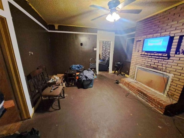 unfurnished room featuring a brick fireplace, a textured ceiling, ceiling fan, and wooden walls