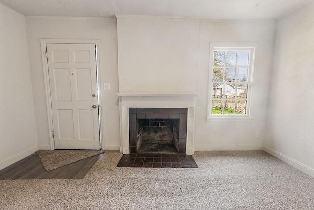 unfurnished living room featuring a fireplace, ornamental molding, and carpet flooring