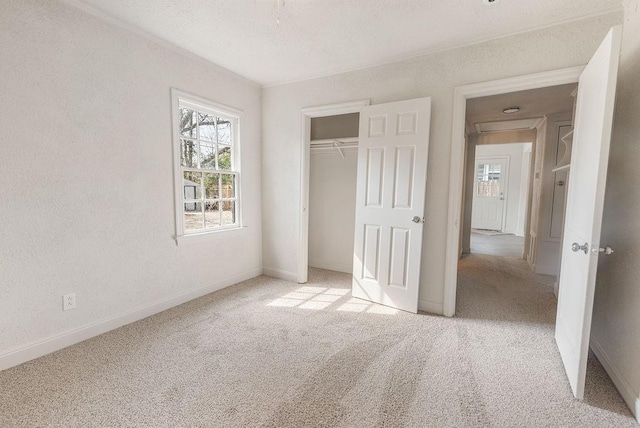 unfurnished bedroom featuring light colored carpet and a closet