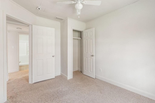 unfurnished bedroom with light carpet, ornamental molding, a closet, and ceiling fan