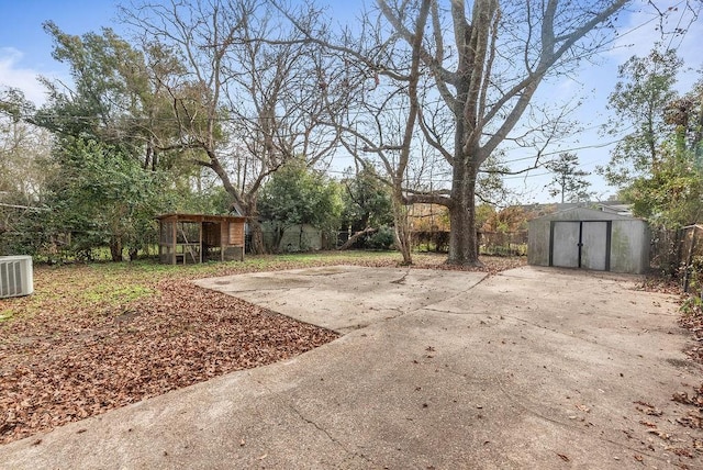 view of yard featuring central AC and a storage shed