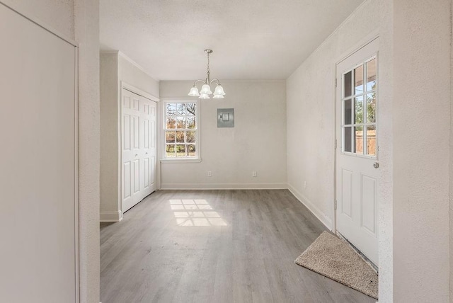 unfurnished dining area with light hardwood / wood-style floors and a notable chandelier