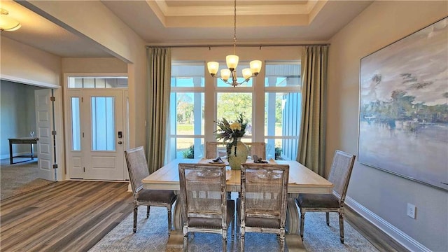 2295 Nadine Ln, Mobile, AL 36695 - dining room featuring wood finished floors, a tray ceiling, healthy amount of natural light, and a chandelier