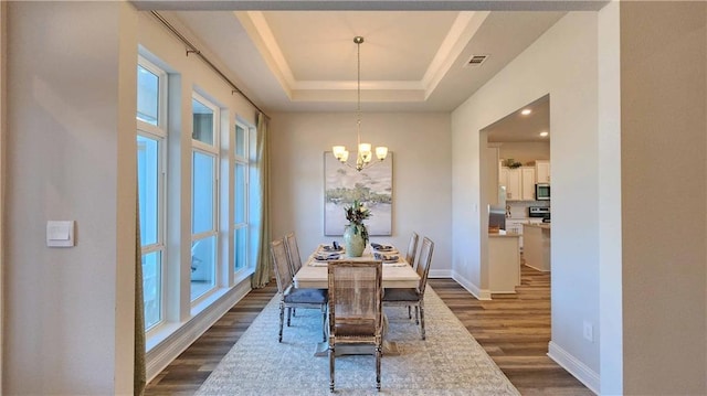2295 Nadine Ln, Mobile, AL 36695 - dining space with dark wood-style flooring, plenty of natural light, a chandelier, and a raised ceiling