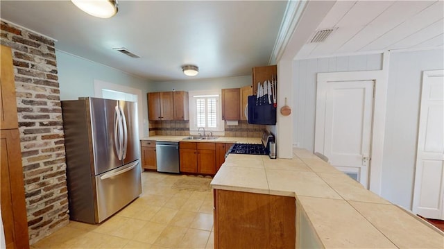 21 Crenshaw St, Mobile, AL 36606 - kitchen with appliances with stainless steel finishes, a sink, crown molding, tile countertops, and brown cabinetry