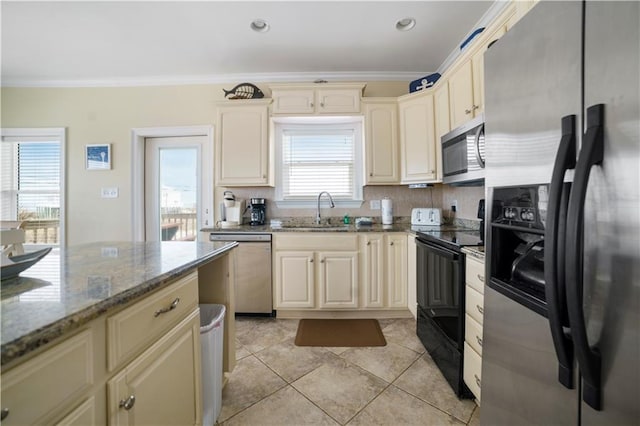 kitchen with stainless steel appliances, tasteful backsplash, cream cabinets, ornamental molding, and a sink