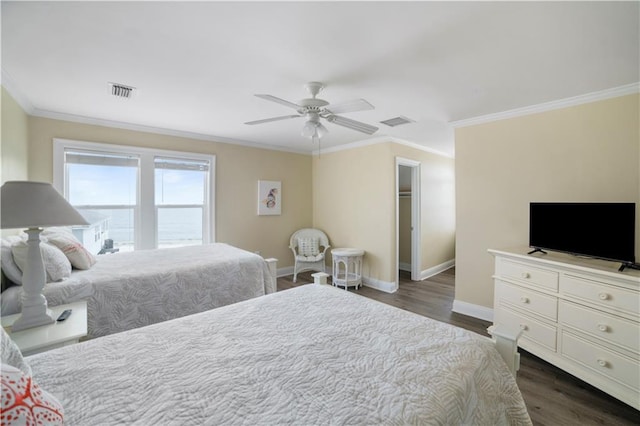 bedroom with ornamental molding, dark wood-style flooring, visible vents, and baseboards