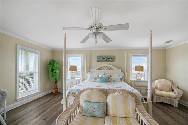 bedroom featuring baseboards, wood finished floors, visible vents, and crown molding