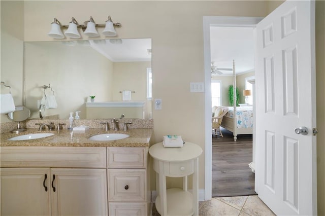 bathroom featuring double vanity, crown molding, connected bathroom, and a sink