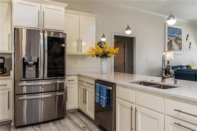 kitchen featuring a sink, decorative light fixtures, ornamental molding, and stainless steel appliances