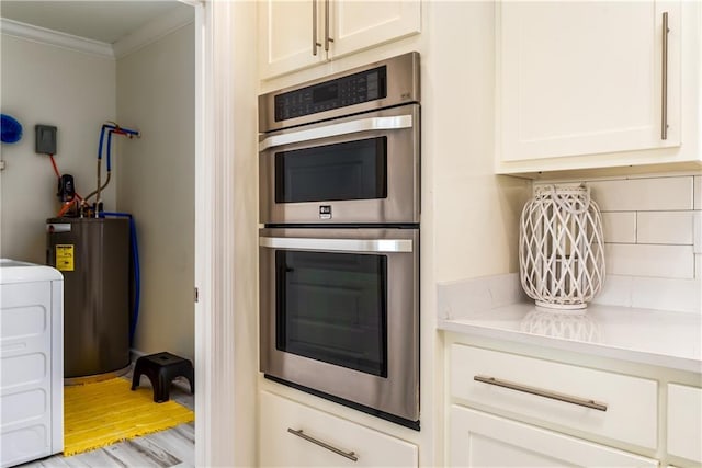 kitchen with tasteful backsplash, water heater, stainless steel double oven, crown molding, and washer / dryer