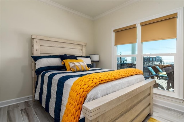 bedroom with wood finished floors, baseboards, and ornamental molding