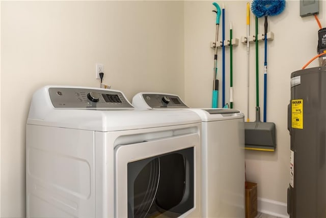 laundry room featuring laundry area, baseboards, water heater, and washing machine and clothes dryer