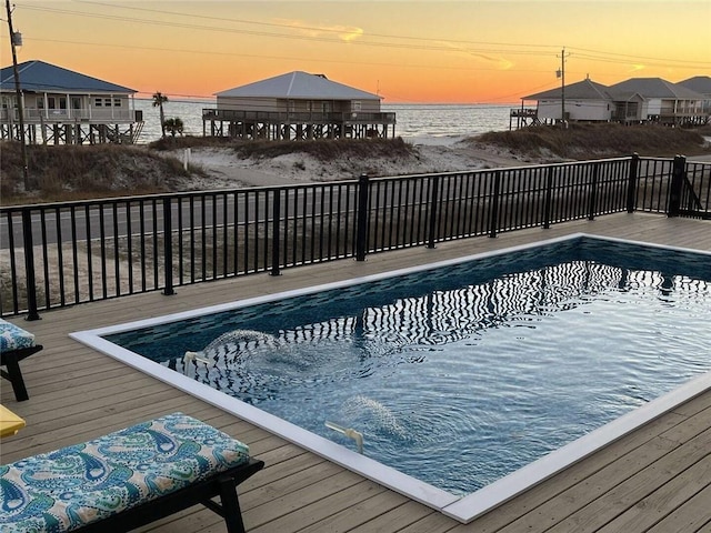 view of swimming pool with a fenced in pool and a water view