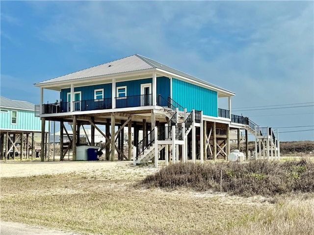 view of front of home with stairs, a porch, and metal roof