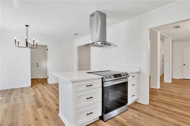 kitchen with white cabinets, island exhaust hood, light hardwood / wood-style floors, crown molding, and stainless steel electric range