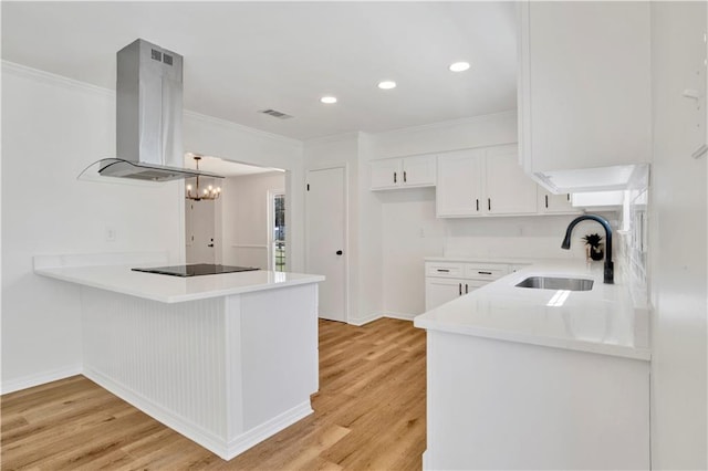 kitchen featuring sink, white cabinets, island exhaust hood, black electric cooktop, and kitchen peninsula