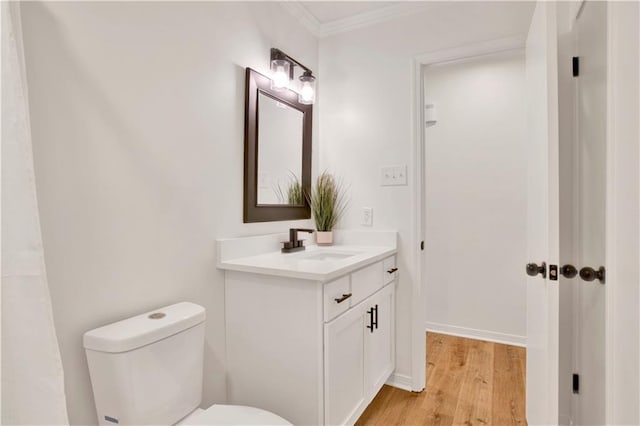 bathroom featuring hardwood / wood-style flooring, vanity, toilet, and crown molding