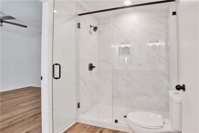 bathroom featuring toilet, a shower with shower door, ornamental molding, hardwood / wood-style flooring, and ceiling fan