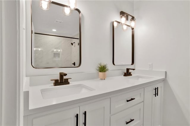 bathroom with a tile shower and vanity