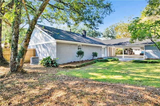 rear view of house featuring a patio, a yard, and central AC unit