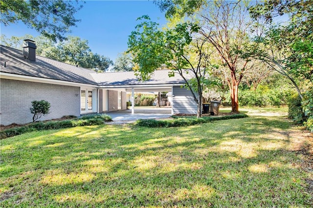 5912 Cansler Dr, Mobile, AL 36609 - view of grassy yard featuring french doors and an attached carport
