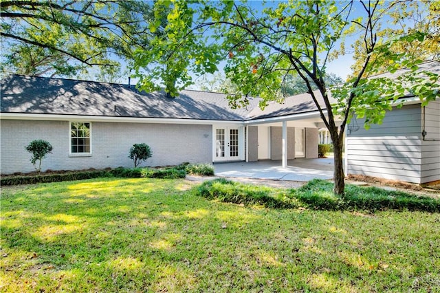 rear view of property with a patio, a lawn, and french doors