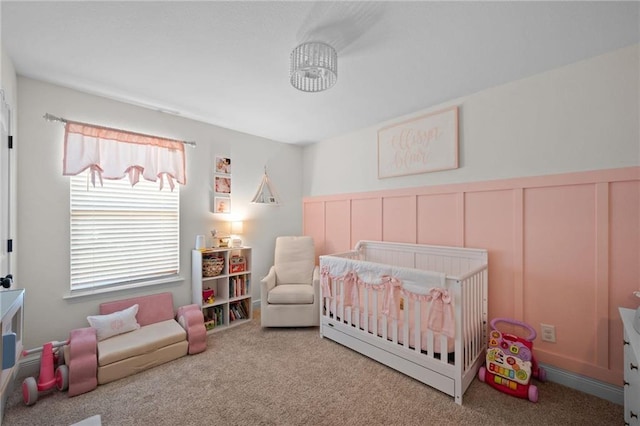 9412 Fox Hunter Ct, Semmes, AL 36575 - bedroom featuring a wainscoted wall, carpet, a nursery area, and a decorative wall