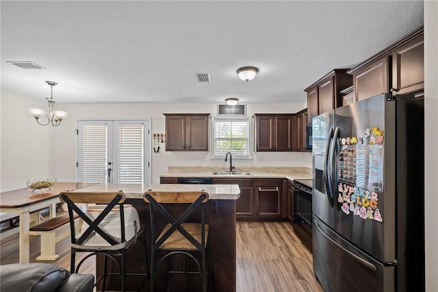 9412 Fox Hunter Ct, Semmes, AL 36575 - kitchen featuring a sink, dark brown cabinets, black electric range, stainless steel fridge with ice dispenser, and light countertops