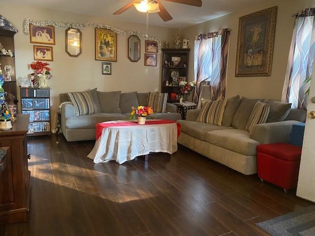 living room featuring ceiling fan and dark hardwood / wood-style flooring