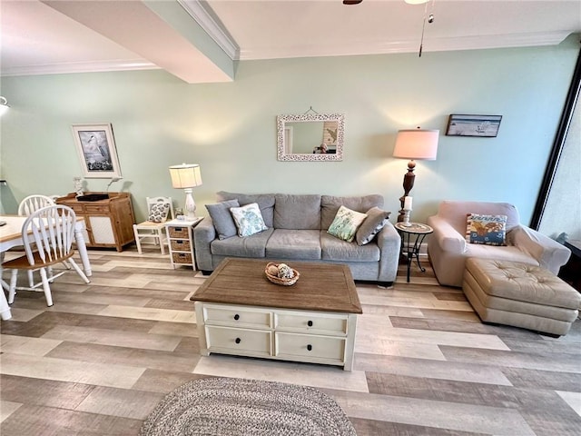 living room featuring crown molding, light wood finished floors, and ceiling fan