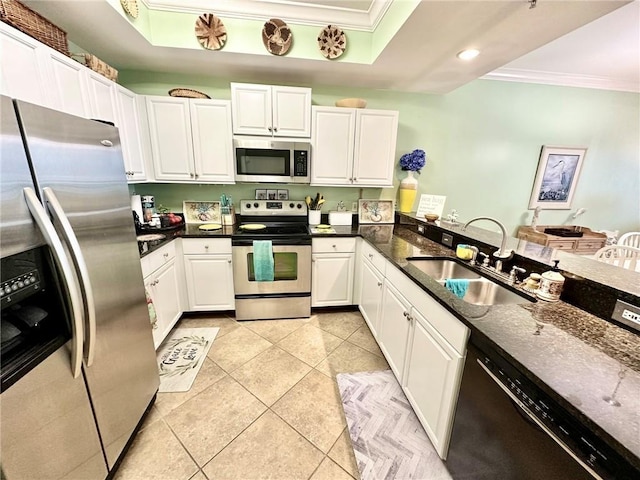 kitchen featuring light tile patterned floors, stainless steel appliances, ornamental molding, white cabinets, and a sink