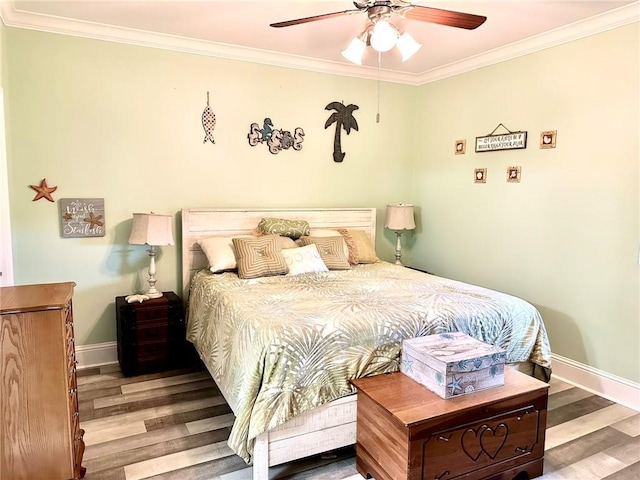 bedroom featuring baseboards, wood finished floors, a ceiling fan, and crown molding