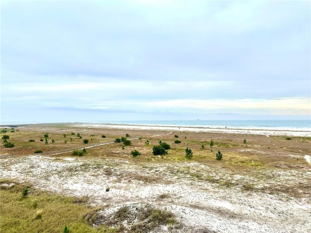 view of landscape with a water view and a beach view