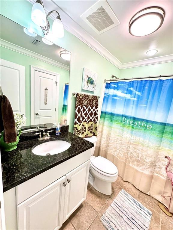 full bathroom with toilet, ornamental molding, vanity, and visible vents