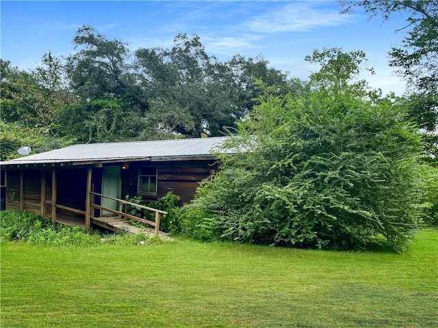 back of property featuring an outdoor structure and a lawn