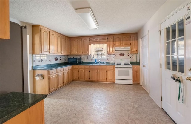 kitchen featuring a textured ceiling, backsplash, sink, and white stove