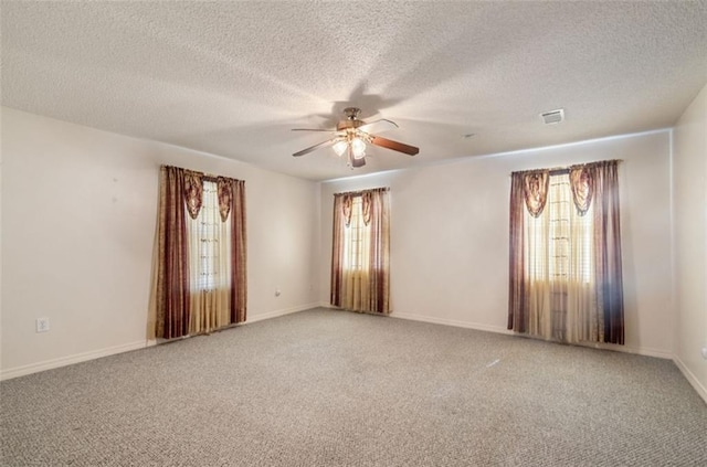 empty room with carpet flooring, ceiling fan, and a textured ceiling