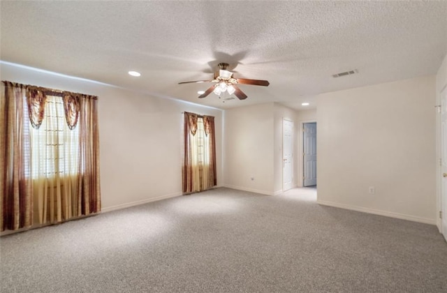 empty room with ceiling fan, plenty of natural light, and light colored carpet