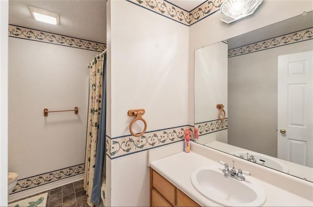 bathroom with a shower with curtain, vanity, and a textured ceiling