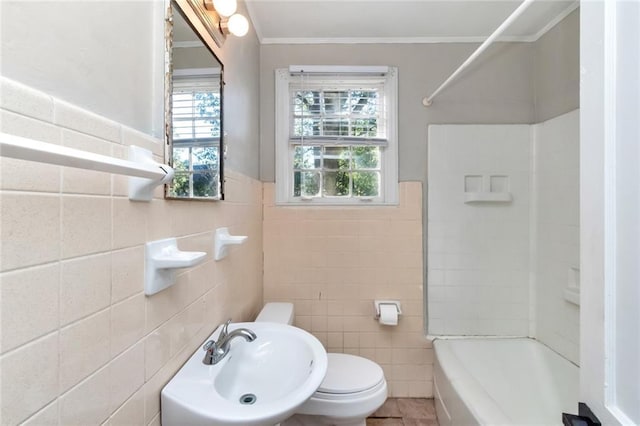 full bathroom featuring bathing tub / shower combination, toilet, ornamental molding, a sink, and tile walls