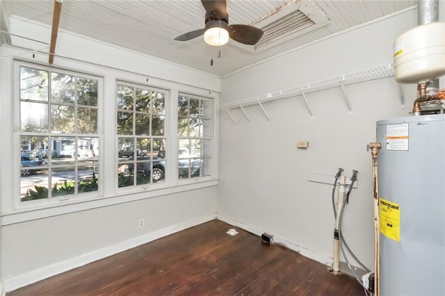 laundry area with a ceiling fan, dark wood-style flooring, water heater, and baseboards