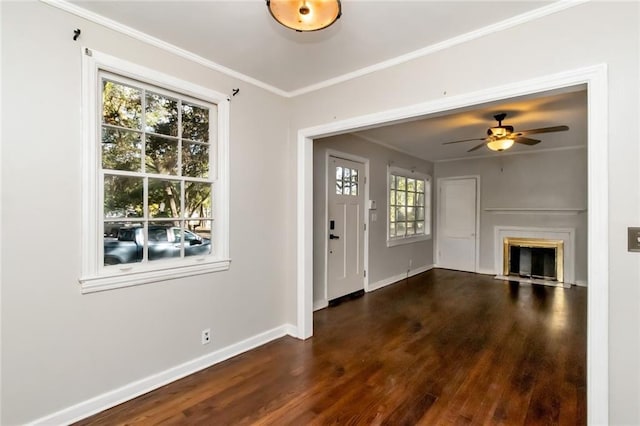 foyer with crown molding, a fireplace with flush hearth, ceiling fan, wood finished floors, and baseboards