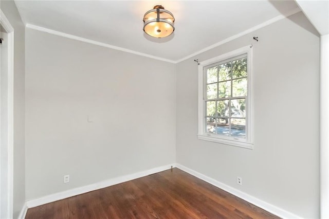 spare room with dark wood-style floors, baseboards, and ornamental molding