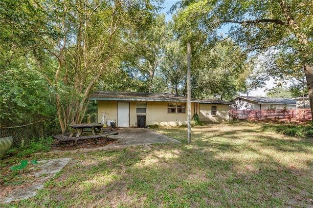 back of house with a patio and a yard