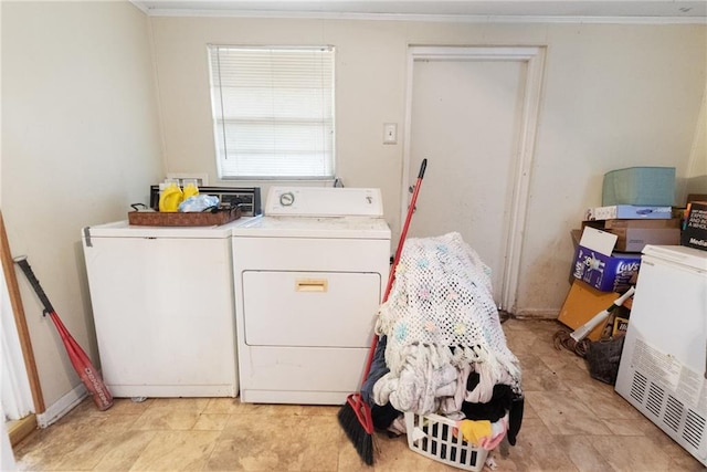 laundry area with ornamental molding and washing machine and clothes dryer