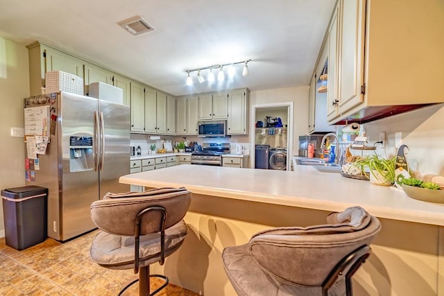 4698 Clarendon Dr, Mobile, AL 36619 - kitchen featuring visible vents, appliances with stainless steel finishes, a peninsula, separate washer and dryer, and a sink